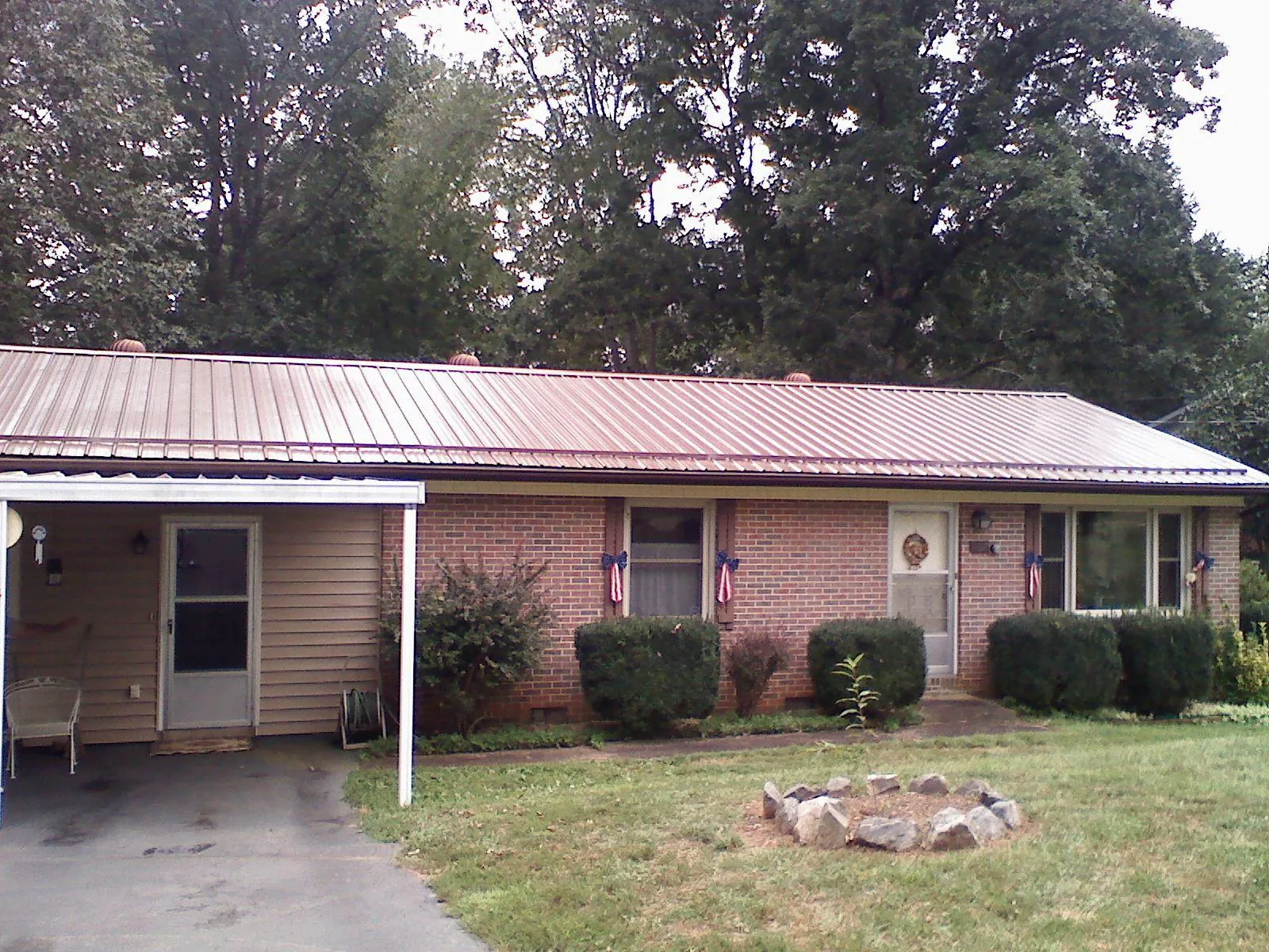 Bronze metal roof and carport on a brick ranch home — Roof Repair work by our crew in Berry